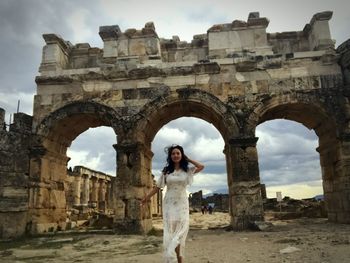 Mid adult woman standing against historical building