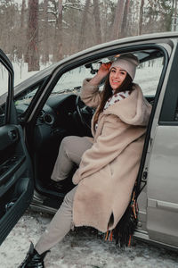 Attractive young female looks out the car window waiting for a trip and smile. winter travel. woman 