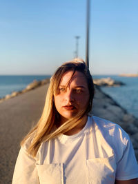 Portrait of woman on beach against clear sky