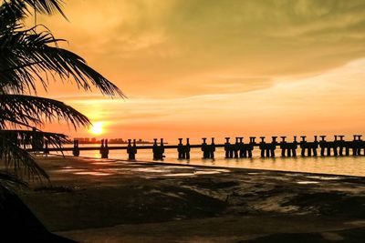 Scenic view of sea against cloudy sky at sunset