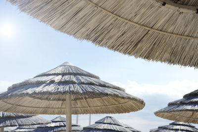 Low angle view of parasols against sky