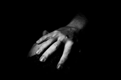 Close-up of human hand against black background