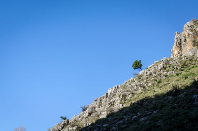 Low angle view of mountain against clear blue sky