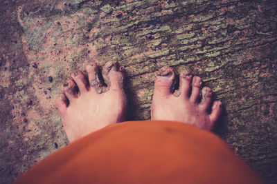 Low section of woman standing in dirt