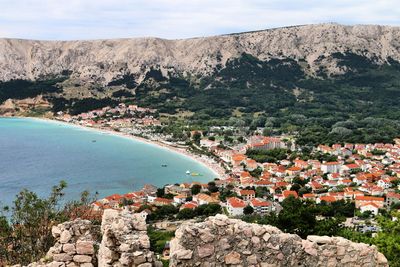 Aerial view of townscape by mountain against sky