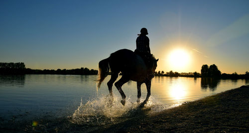 Silhouette of one person riding at sunset