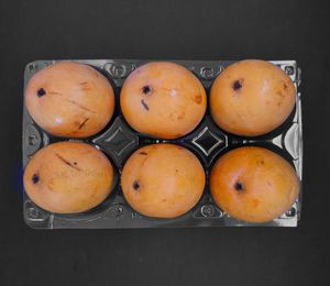 High angle view of orange eggs against black background