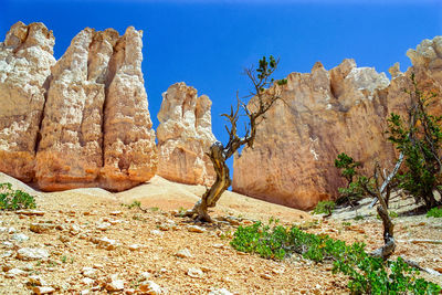 Rock formations on landscape against blue sky