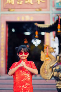 Midsection of woman with sculpture in background