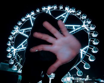 Close-up of hand using smart phone against black background