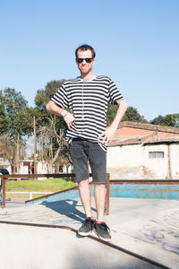 Young man wearing sunglasses standing against the sky