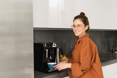 Portrait of young woman standing at home