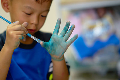 Cute boy painting hand