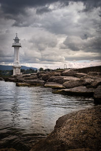 Lighthouse by sea against sky