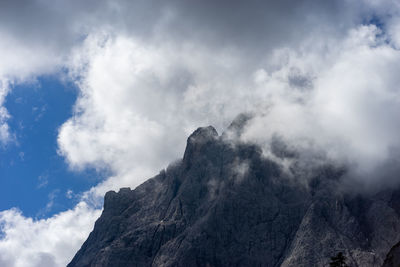 Low angle view of rocky mountains against sky