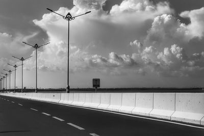 Street lights on highway against sky