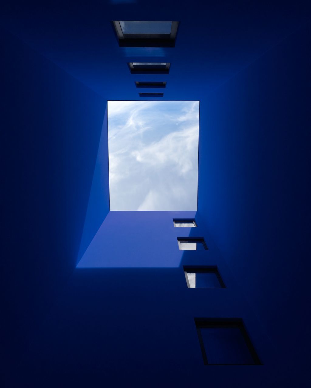 architecture, built structure, sky, low angle view, no people, building, nature, building exterior, blue, day, wall - building feature, cloud - sky, sunlight, outdoors, window, directly below, geometric shape, tall - high, pattern, skyscraper