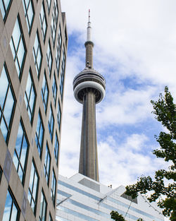 Low angle view of communications tower against cloudy sky