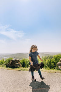 Full length of girl on road against sky