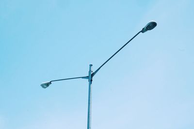 Low angle view of power lines against clear blue sky