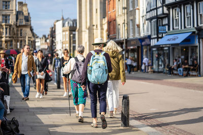 Rear view of people walking on street in city