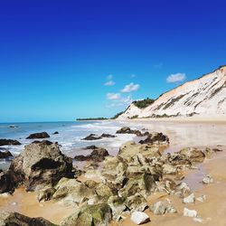 Scenic view of beach against blue sky