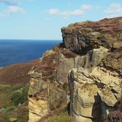 Rock formations by sea against sky