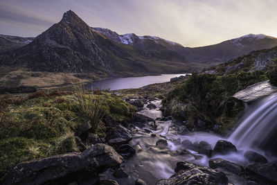 Scenic view of river amidst mountains against sky