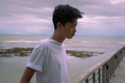 Man standing at beach against sky