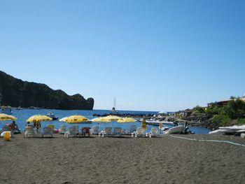 Scenic view of beach against clear blue sky