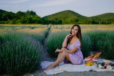 Portrait of young woman sitting on field