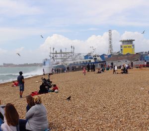 People at beach against sky