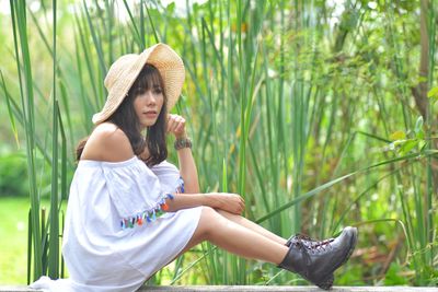 Young woman sitting on plants