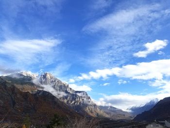 Scenic view of mountains against cloudy sky