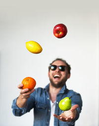 Full length of man holding apple against white background