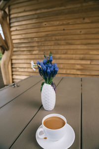 Coffee cup and potted plant on table