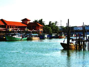 Boats in river with buildings in background