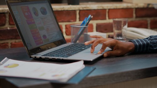 Cropped hand using laptop on table