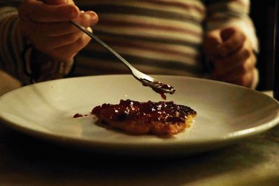 Close-up of person eating food in plate