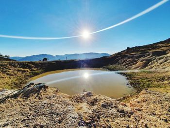 Scenic view of mountains against sky on sunny day