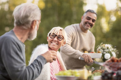 Rear view of man and woman sitting in yard