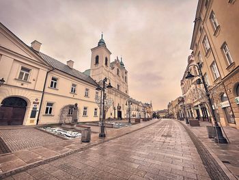 Street amidst buildings against sky in city