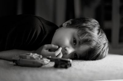 Portrait of cute baby girl lying on toy at home