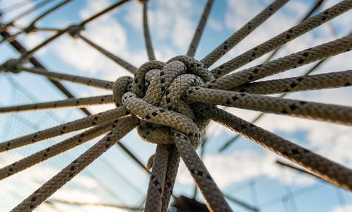 Close-up of rope tied on bollard against sky