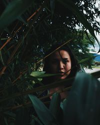 Close-up of young woman with tree