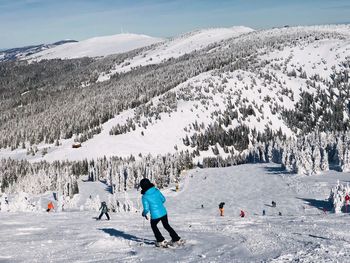 Rear view of woman skiing on snowcapped mountain