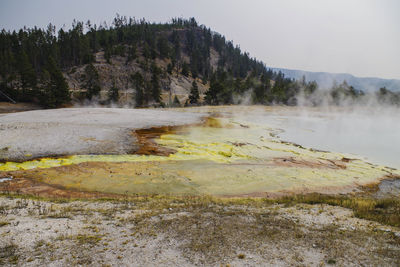 Scenic view of hot spring against sky