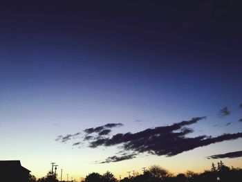 Low angle view of silhouette trees against sky