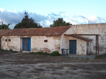 Abandoned house on field against sky