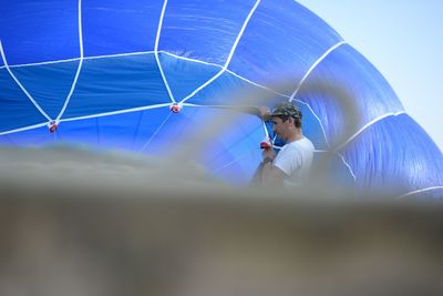 Low angle view of woman against blue sky